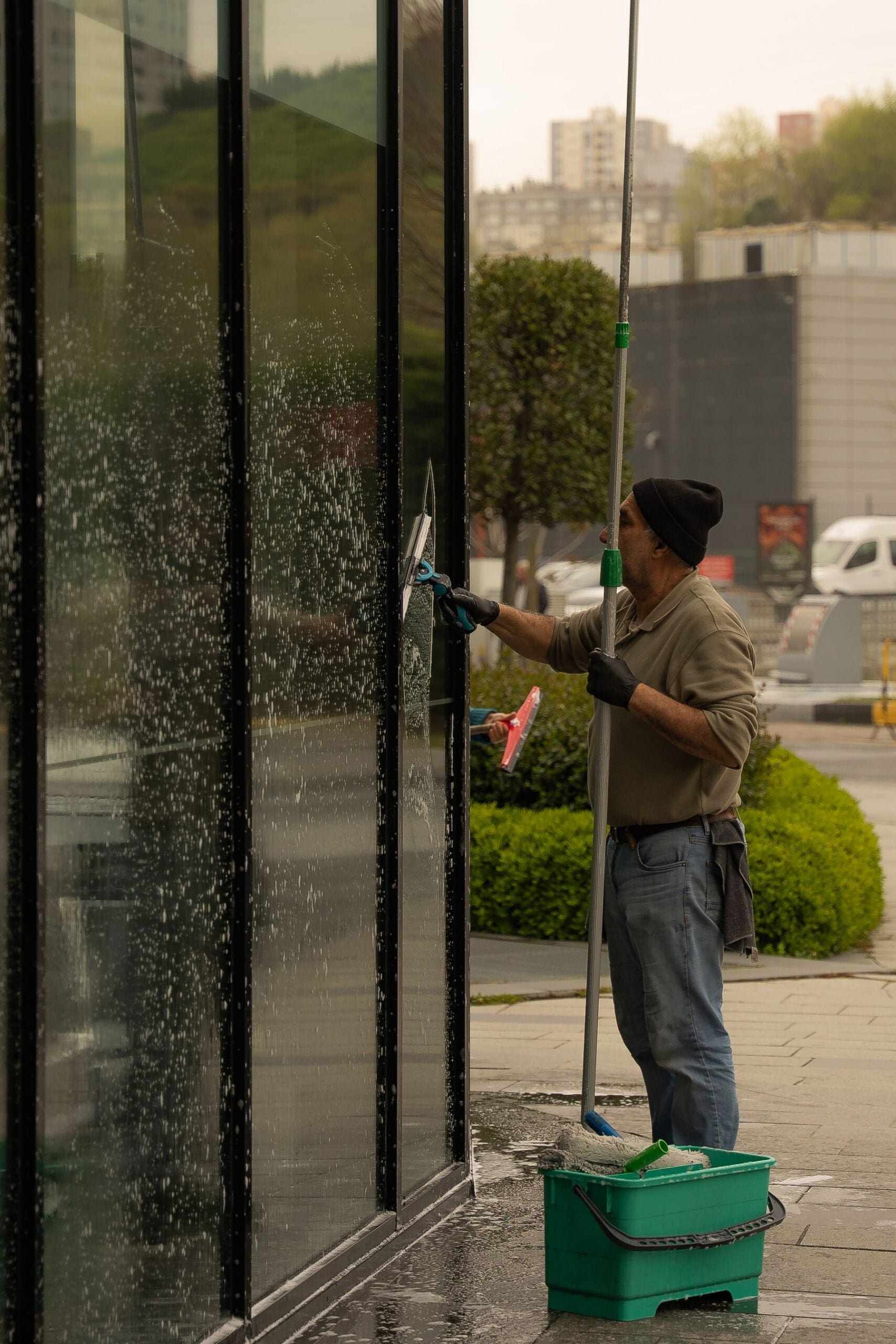 Professional window cleaner using a squeegee on exterior glass